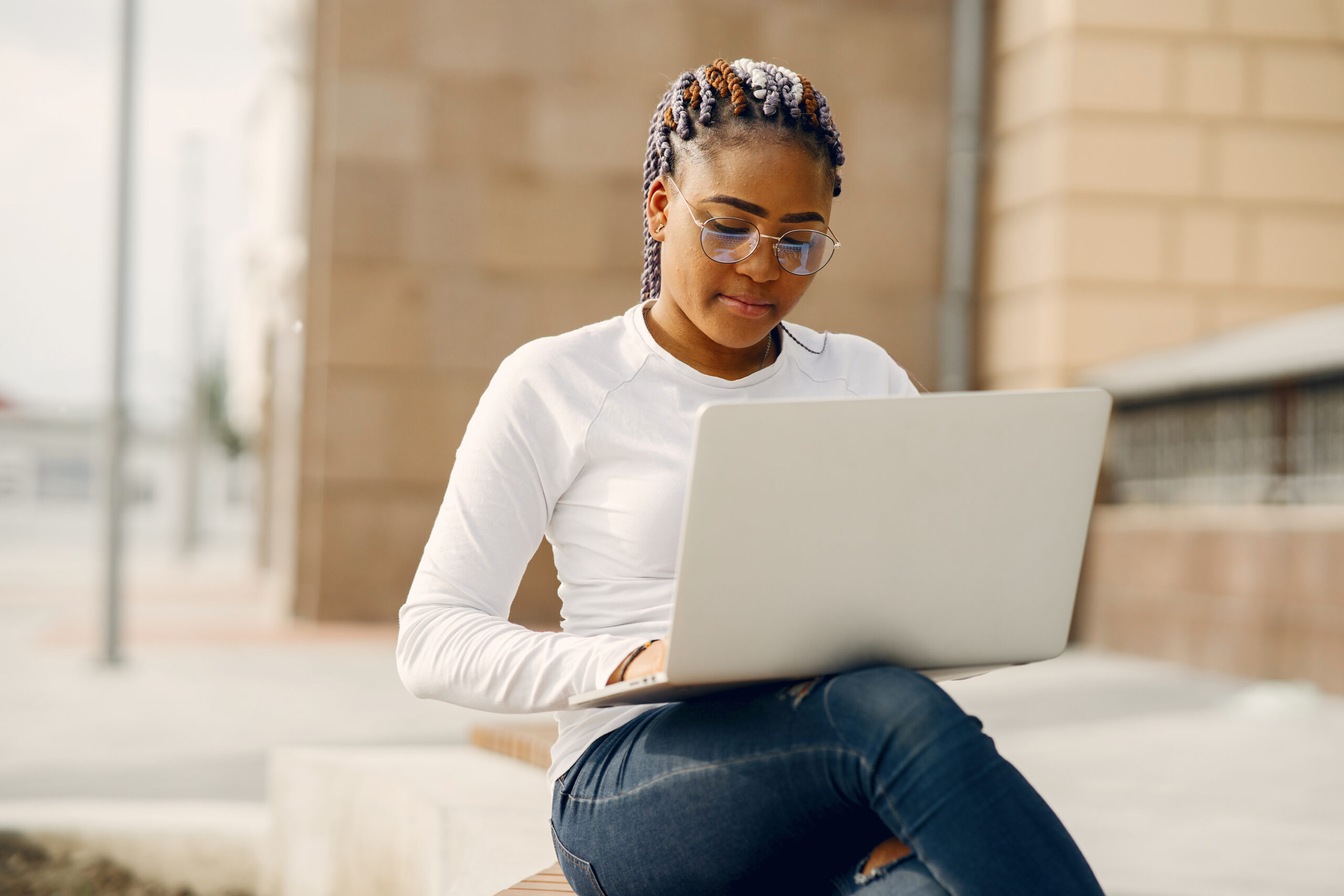 Black girl in a summer city with laptop